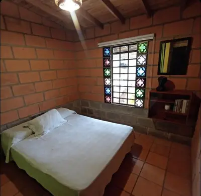 a bedroom with a white bed and a window at Finca Oriente Antioqueño Guarne Rionegro in Guarne