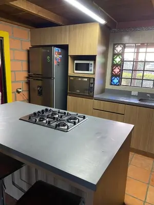 a kitchen with a stove and a refrigerator at Finca Oriente Antioqueño Guarne Rionegro in Guarne