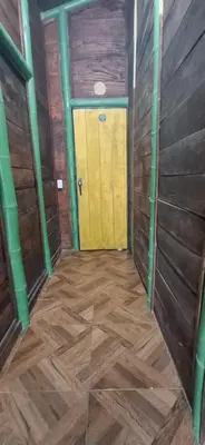 a room with a yellow door and wooden walls at Cabaña Los Almendros in Puerto Triunfo