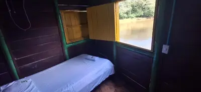 a small room with a bed and a window at Cabaña Los Almendros in Puerto Triunfo