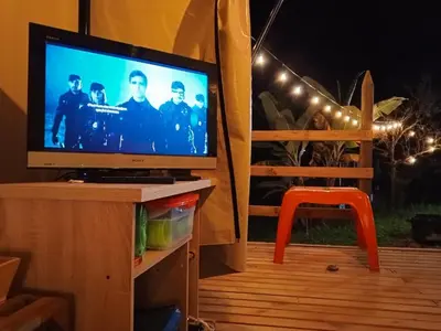a tv sitting on a stand with a tv screen at Casa incluyendo Glamping! 13 personas, Familias con niños in Jardin