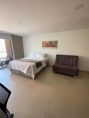 a bedroom with a bed and a chair at Acogedor y cómodo apartamento in Sabaneta