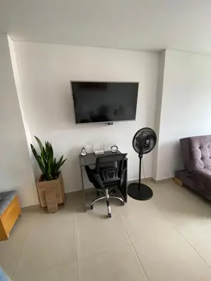 a living room with a desk and a tv on the wall at Acogedor y cómodo apartamento in Sabaneta