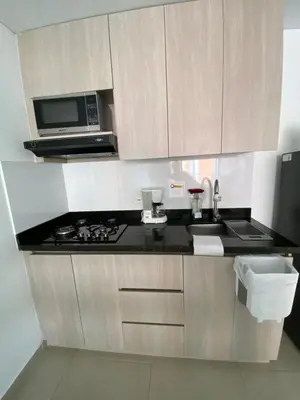 a kitchen with a stove and a microwave at Acogedor y cómodo apartamento in Sabaneta