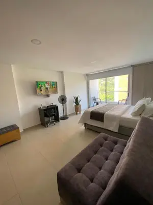 a large bedroom with a bed and a couch at Acogedor y cómodo apartamento in Sabaneta