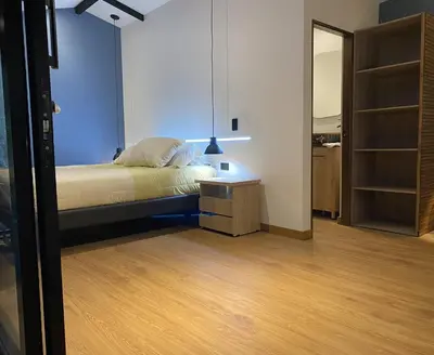 a bedroom with a bed and a dresser and a mirror at Luxury Cabin in the Forest in El Retiro
