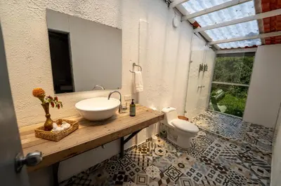 a bathroom with a sink and a toilet at Tinamú Birding and Nature Lodge in Manizales