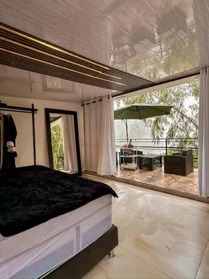 a bedroom with a bed and a view of a patio at Le Jardin d A in Santa Bárbara