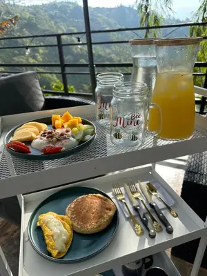 a table with two plates of breakfast food and orange juice at Le Jardin d A in Santa Bárbara