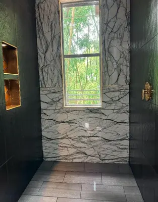 a bathroom with a window and a stone wall at Le Jardin d A in Santa Bárbara