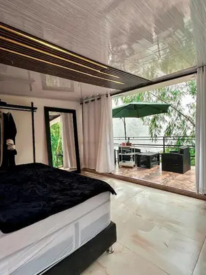 a bedroom with a bed and a patio with an umbrella at Le Jardin d A in Santa Bárbara