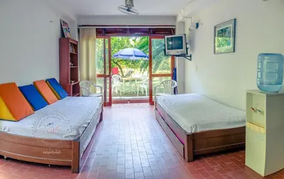 a bedroom with two beds and a tv and a patio at Apartamento Campestre La Florida in La Florida