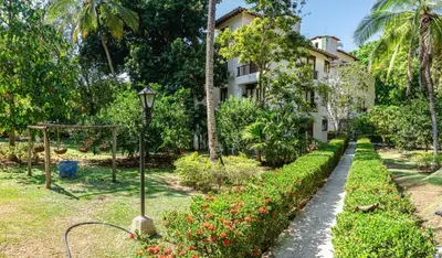 a garden with a building and a street light and flowers at Apartamento Campestre La Florida in La Florida