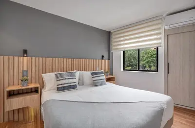 a bedroom with a large bed and a window at Apartamento con aire laureles201 in Medellín