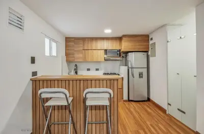 a kitchen with a counter and two stools at Apartamento con aire laureles201 in Medellín