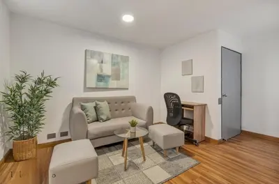 a living room with a couch and a desk at Apartamento con aire laureles201 in Medellín