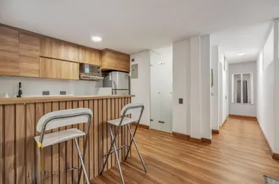 a kitchen with two bar stools in front of a counter at Apartamento con aire laureles201 in Medellín