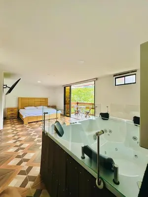 a large bathroom with a bath tub with a bed at La camelia in Jardin