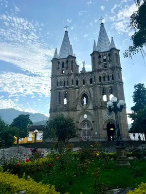 a building with two towers with flowers in front of it at La camelia in Jardin