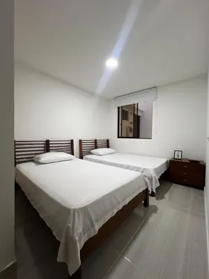 two beds in a white room with a mirror at La camelia in Jardin