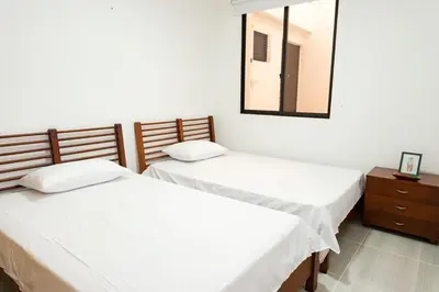 two beds in a room with a mirror and a dresser at La camelia in Jardin