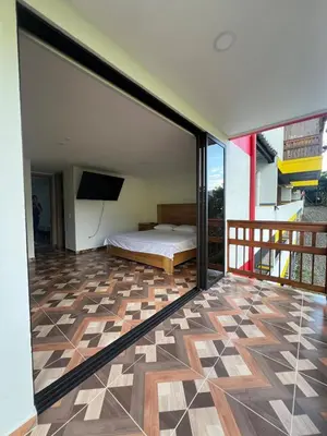 a bedroom with a bed on a balcony at La camelia in Jardin