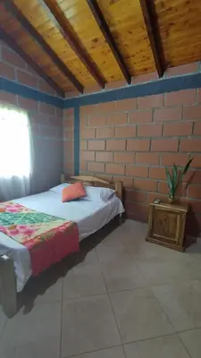 a bedroom with a bed and a brick wall at Cabaña Mirador Santa Ana in San Rafael