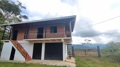 a house with a balcony and a motorcycle in front of it at Cabaña Mirador Santa Ana in San Rafael