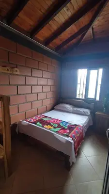 a bed in a room with a brick wall at Cabaña Mirador Santa Ana in San Rafael