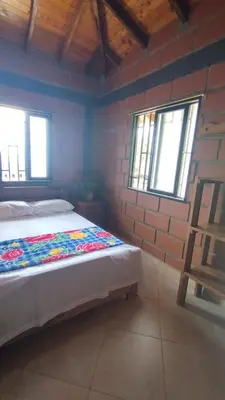 a bedroom with a bed and a brick wall at Cabaña Mirador Santa Ana in San Rafael