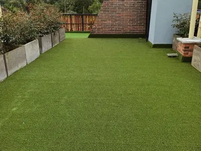 a yard with green grass and a brick fence at New Countryside Apartaloft 213 in El Retiro