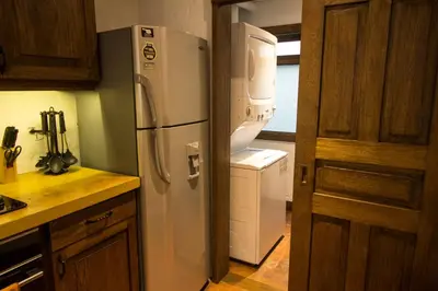 a kitchen with a refrigerator and a washer and dryer at Casa Del Reloj in Medellín