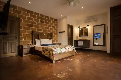 a bedroom with a bed and a brick wall at Casa Del Reloj in Medellín