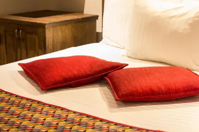two red pillows are sitting on a bed at Casa Del Reloj in Medellín