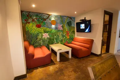 a living room with orange furniture and a mural at Casa Del Reloj in Medellín