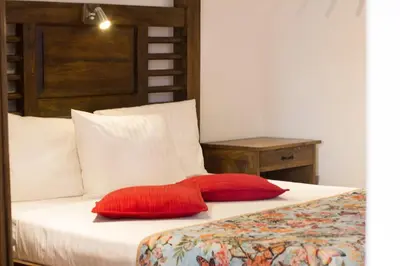 a bed with two red pillows on it at Casa Del Reloj in Medellín