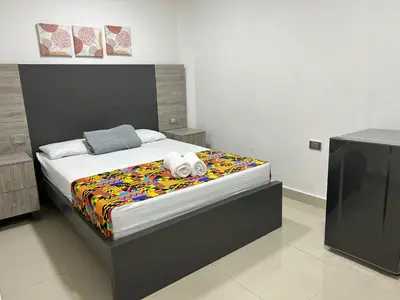 a bedroom with a large bed with a colorful blanket at Hotel Ciento Once Boutique Laureles in Medellín
