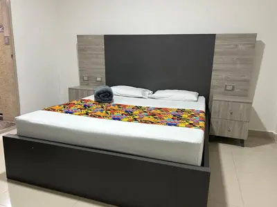 a bed with a stuffed animal sitting on top of it at Hotel Ciento Once Boutique Laureles in Medellín