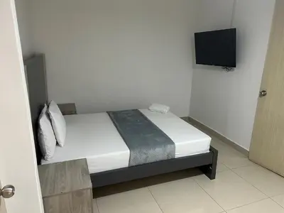 a bedroom with a bed with a tv on the wall at Hotel Ciento Once Boutique Laureles in Medellín