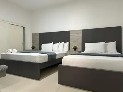 two beds in a room with two beds sidx sidx sidx at Hotel Ciento Once Boutique Laureles in Medellín