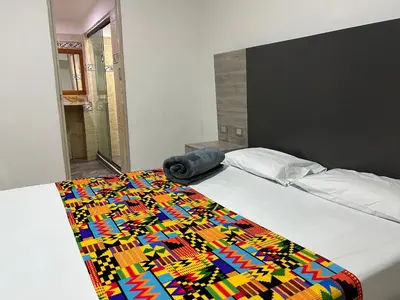 a bed with a colorful blanket on top of it at Hotel Ciento Once Boutique Laureles in Medellín