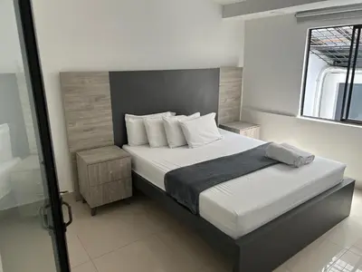 a bedroom with a bed with white sheets and pillows at Hotel Ciento Once Boutique Laureles in Medellín