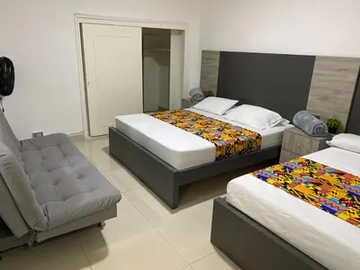 a hotel room with two beds and a couch at Hotel Ciento Once Boutique Laureles in Medellín
