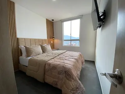 a bedroom with a bed with a large window at Lujoso y acogedor apartamento in Sabaneta