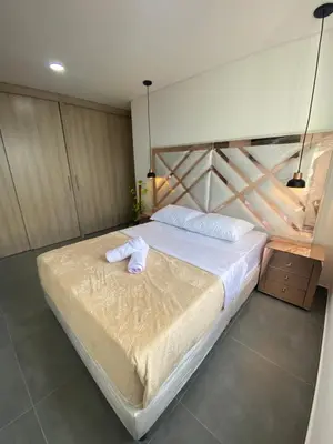 a bedroom with a large bed with white sheets at Lujoso y acogedor apartamento in Sabaneta