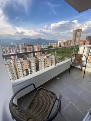 a balcony with a chair and a view of a city at Lujoso y acogedor apartamento in Sabaneta