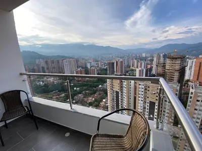 a balcony with two chairs and a view of a city at Lujoso y acogedor apartamento in Sabaneta