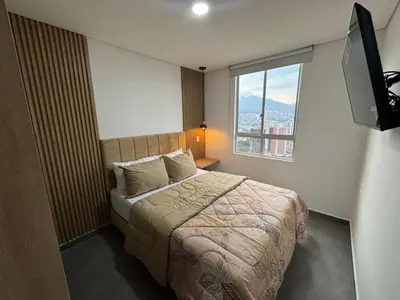 a bedroom with a bed and a large window at Lujoso y acogedor apartamento in Sabaneta