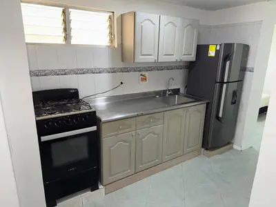 a kitchen with a stove and a refrigerator at Cómodo Family Laureles-Estadio 4BR cerca la 70 maximo 10 personas in Medellín
