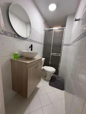 a bathroom with a sink and a toilet and a mirror at Cómodo Family Laureles-Estadio 4BR cerca la 70 maximo 10 personas in Medellín